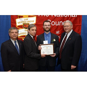 An unidentified inductee poses with his certificate and three others at The National Council Dinner