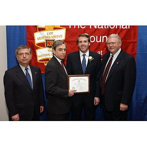 New inductee poses with three others and his certificate at The National Council Dinner