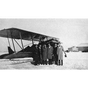 Members of the Northeastern Flying Club stand in front of a plane