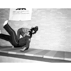 A student throws down a police officer during a judo demonstration