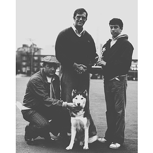 A young man receives an award next to King Husky, Northeastern University's school mascot