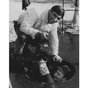 Co-op student Kenneth A. Coletta over a manhole while working for Boston Edison Company