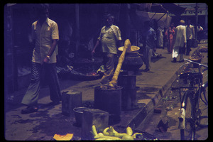 Street scene with vendors and distillation set-up (?)