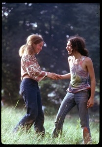 Hippie couple in tie-dye and Indian print, cavorting through the fields, Woodstock Festival