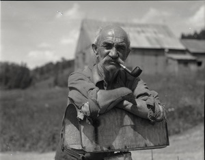 Mr. Kidder, leaning on a mailbox, smoking a pipe