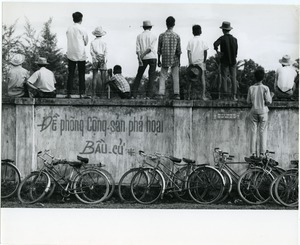 Men standing atop wall