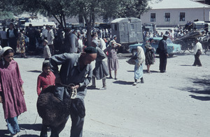 Man leading Uzbek black goat at a market