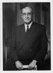 Frank L. Boyden standing and holding book