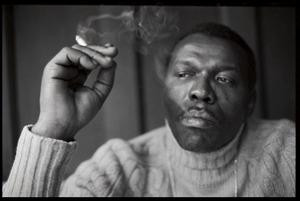 Elvin Jones: half-length portrait of jazz musician, seated, smoking a cigarette