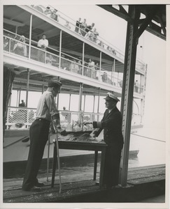 Captain Frank Brown shows model ship to Robert Wright