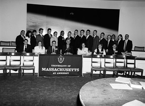Congressman John W. Olver with visitors to the capitol, seated behind a UMass Amherst banner