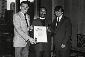 Mayor Raymond L. Flynn and Real Property Commissioner J. Edward Roche with an unidentified minister holding a proclamation