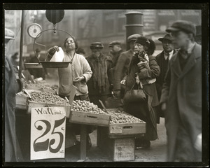 Elderly woman purchasing walnuts from a street vendor