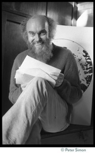 Ram Dass seated in front of a print of Neem Karoli Baba at the house at 181 Vicente Street