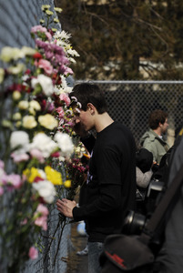 Justice for Jason rally at UMass Amherst: protesters in support of Jason Vassell placing flowers in a chain link fence