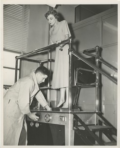 A technician makes a mold of a woman's foot for a prosthetic device as two men, including Bruce Barton, look on