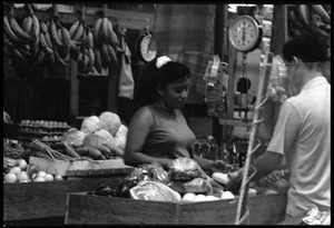 Woman selling produce from a market stall in the old marketplace, Belize City