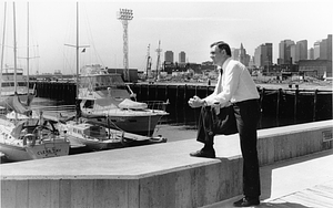 Mayor Raymond L. Flynn looking towards Boston Harbor while standing on a dockside