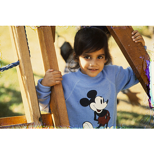 Child in Mickey Mouse sweater playing outside