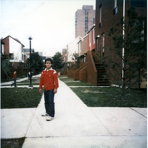 Boy standing on the sidewalk in the Villa Victoria neighborhood.