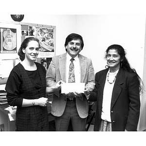Clara Garcia and two other staff members displaying a check.