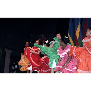 Girls performing a folk dance on stage.