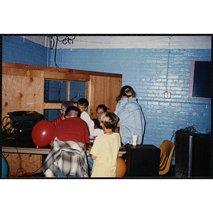 A Group of children huddled around a table during an open house