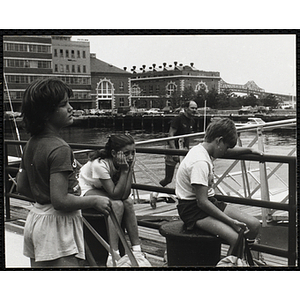 Several children sitting and waiting on a pier at the Charlestown Navy Yard