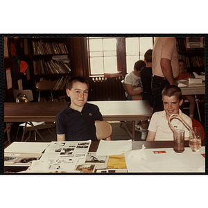 Two boys sitting with their science fair projects