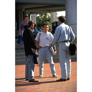 Three students speaking in front of Snell Library