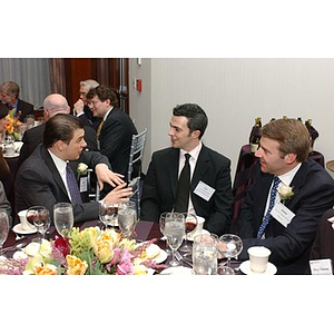 James Bonetti, Lee Pichette, and another man converse while they sit at The National Council Dinner