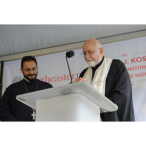 Two figures from the Greek Orthodox Church say a prayer at the groundbreaking ceremony
