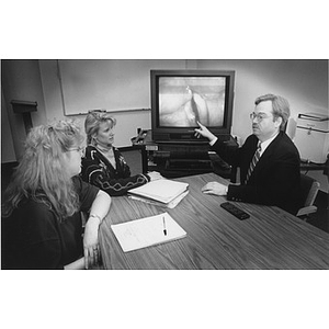 Assistant Speech Pathology Prof. Robert Peppard shows graduate students Marnie Sullivan (left) and Susan Milligan examine a close up of the vocal chord system