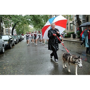 A participant leads a fellow Husky during the Homecoming parade