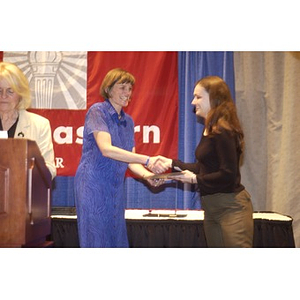 Gail Olyha shaking hands with an award recipient at the Student Activities Banquet