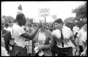 Unidentified man tending to David Dellinger and Staughton Lynd after they were attacked with red paint by right wing counterprotesters: Assembly of Unrepresented People peace march on Washington