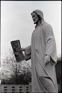 Statue of Jesus, copy of Free Spirit Press magazine set in his hand