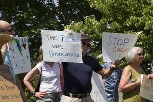 Pro-immigration protesters and signs outside the Chatham town offices building, one with sign reading 'The Pilgrims were undocumented' : taken at the 'Families Belong Together' protest against the Trump administration's immigration policies