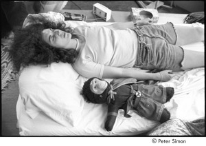 Ram Dass retreat at David McClelland's: unidentified woman lying on a bed with a monkey doll