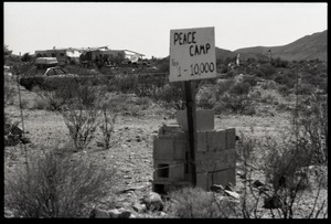 Close-up of 'Peace camp, Pop 1-10,000' sign and cinder blocks at Nevada Test Site peace encampment