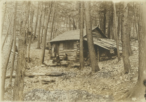 Cabin in woods with three unidentified women in front