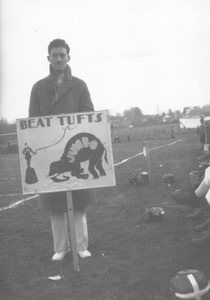 Football booster holding sign at campus game