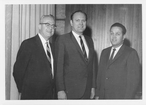 John W. Lederle standing inside with two unidentified men