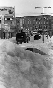 Pedestrians and vehicles on snowy Blue Hill Avenue and Warren Street