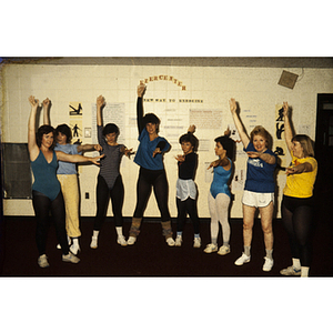 Women doing dance moves in front of a poster