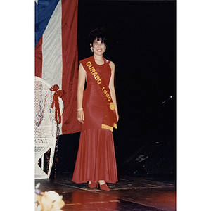 Chamely Toro wears a red dress and a Gurabo 1996 sash on stage