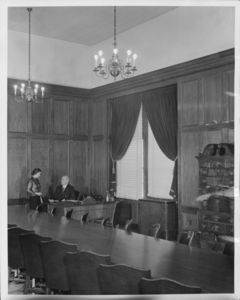 Catherine Carraher (secretary of Suffolk Law School) and Suffolk University President Gleason L. Archer (at desk) in the Archer Building (20 Derne Street) Trustees Room