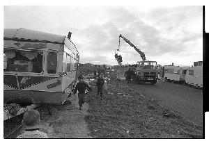 Council workers cleaning up traveller halting site, Flying Horse Road, Downpatrick. Travellers looking on