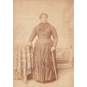 An African American woman standing with an umbrella
