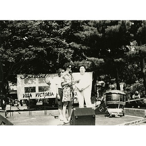 Woman at the microphone on the outdoor stage at Festival Betances.